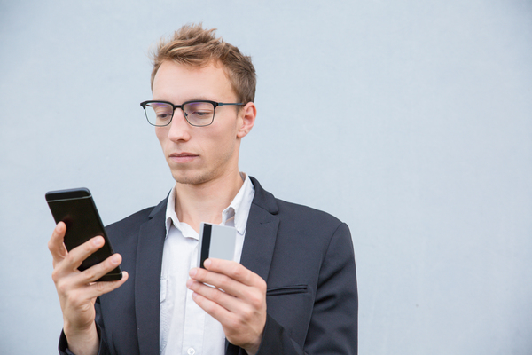 Mężczyzna korzystający z telefonu podczas płatności BLIK